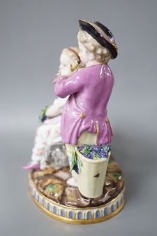 A 19th century Meissen figure group of a boy with a pipe, a girl with a grape and a goat, crossed swords in blue, incise letters and numbers. 15cm